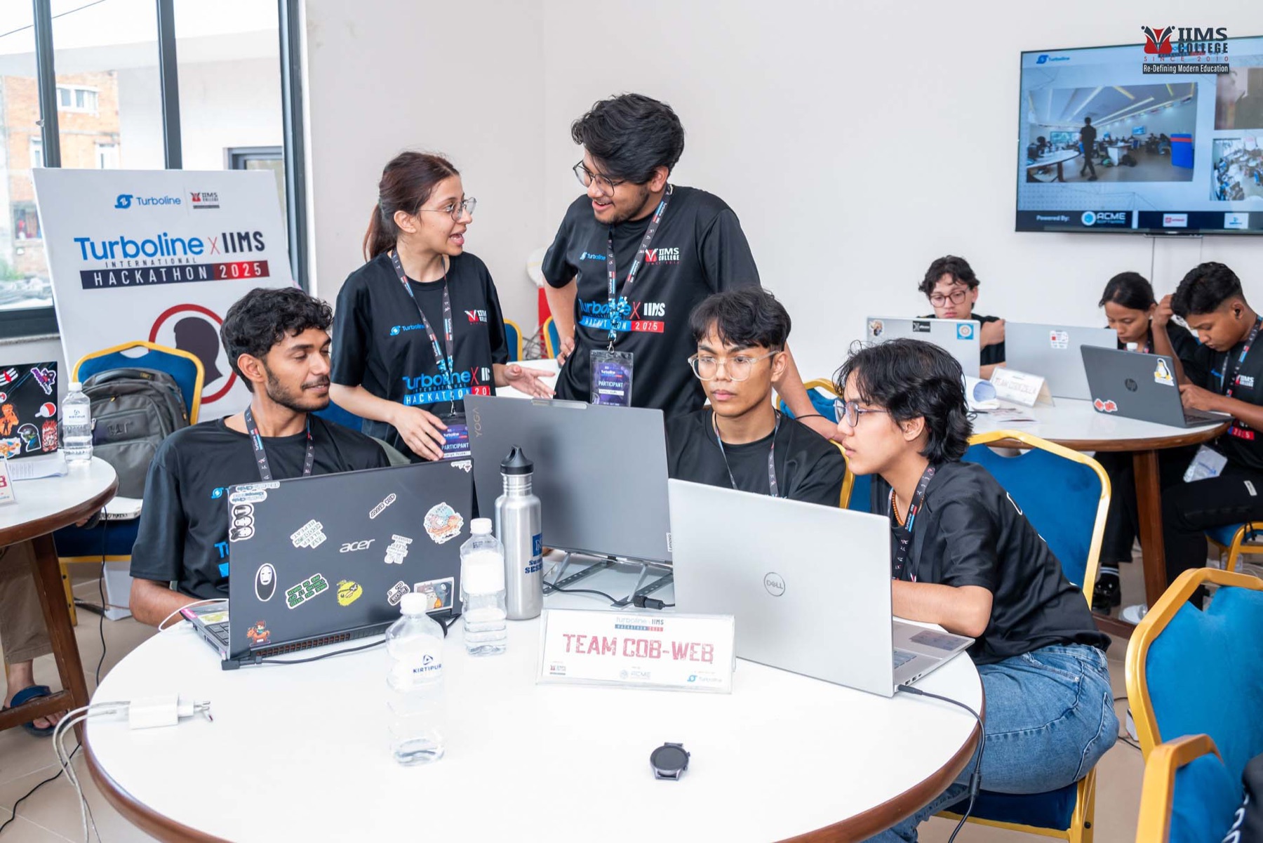 A mentor reviewing a student team's work during the second day