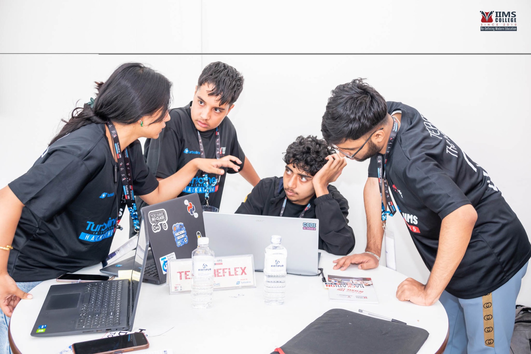 A student team collaborating around laptops during the hackathon